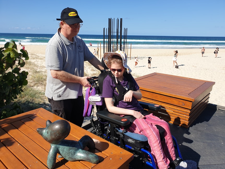 Tara Ingerson in her wheelchair with her father David at the beach. 