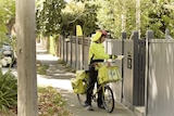 A post man delivering mail for Australia Post.