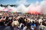 The crowd cheers as 69 cars perform a simultaneous burnout at Summernats 2013.