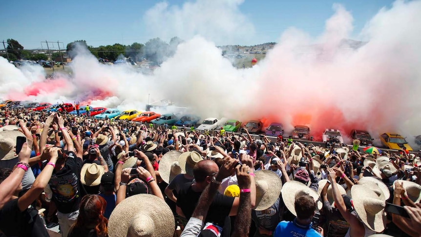 The crowd cheers as 69 cars perform a simultaneous burnout at Summernats 2013.