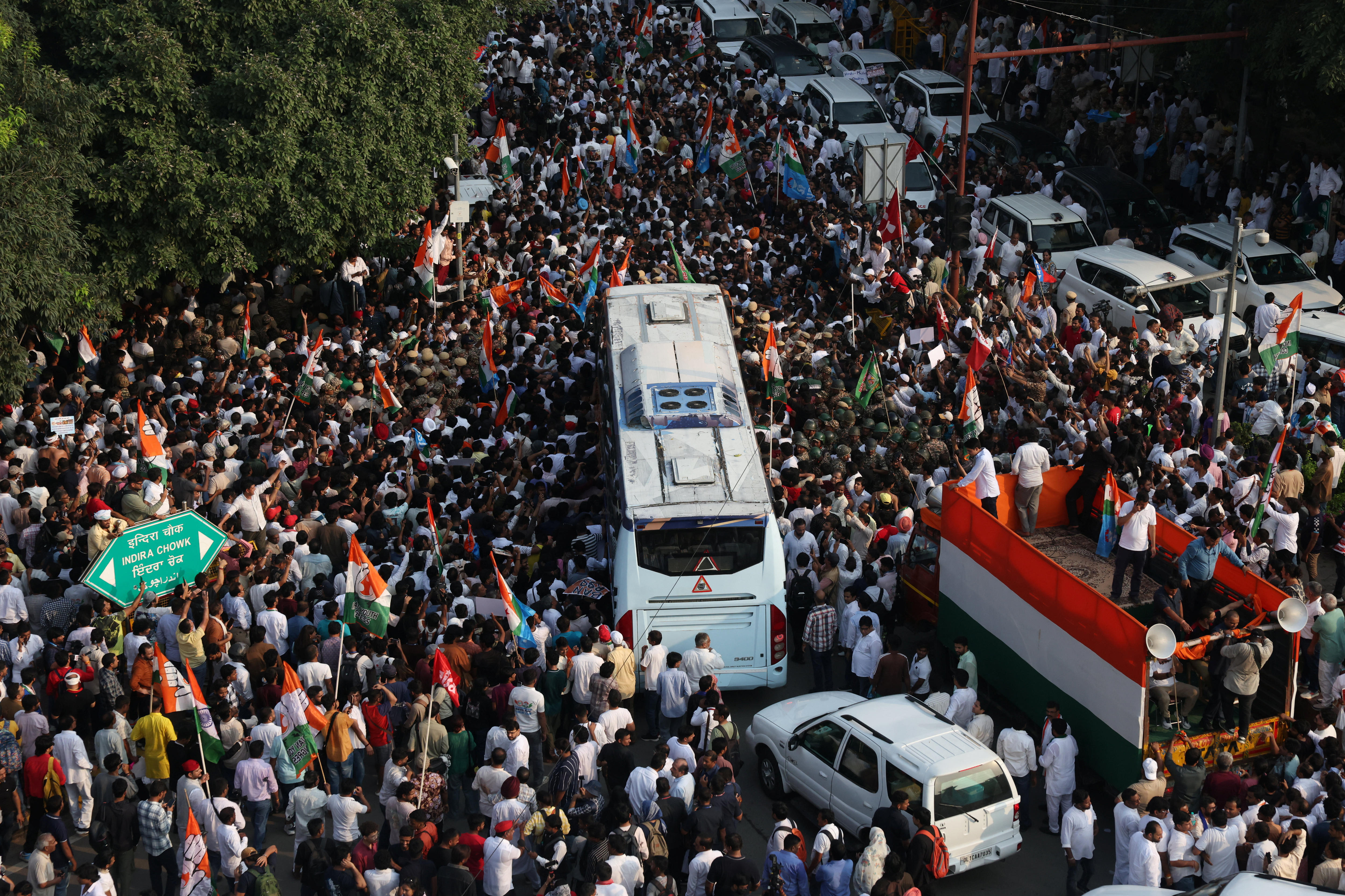 An aerial photo of thousands of people carrying India flags crammed into a street.