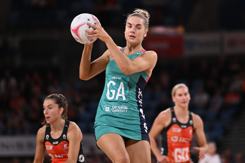 A Melbourne Vixens Super Netball player holds the ball against the Giants.