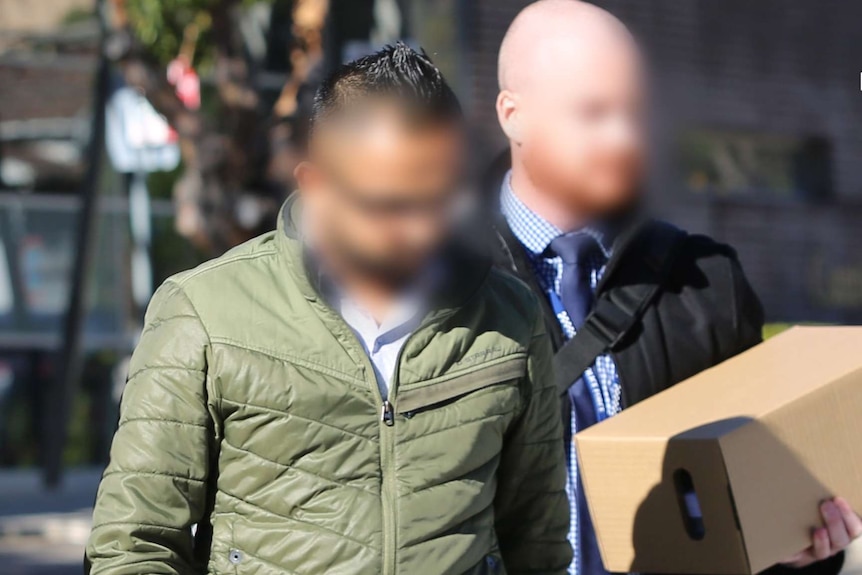 A blurred image of one of the men (left) charged over the alleged syndicate.