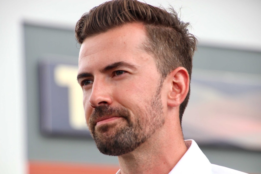 A close up of Zak Kirkup with a slight smile, wearing a white business shirt.