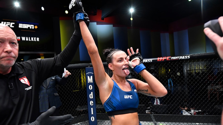 A woman celebrates victory in a UFC bout