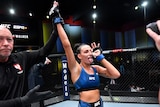 A woman celebrates victory in a UFC bout