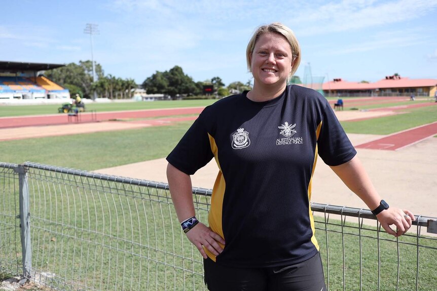 Australia team athletics captain for the Invictus Games Brigid Baker leaning against the fence.