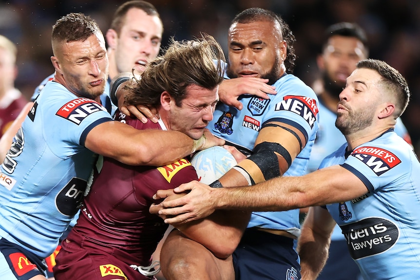 A man runs the ball during an NRL match