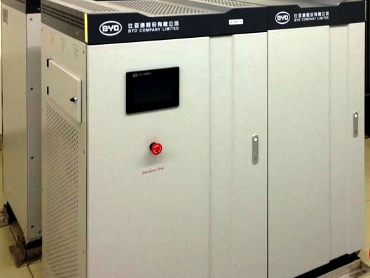 A BYD lithium battery in a tall rectangular metal case sits on the ground.