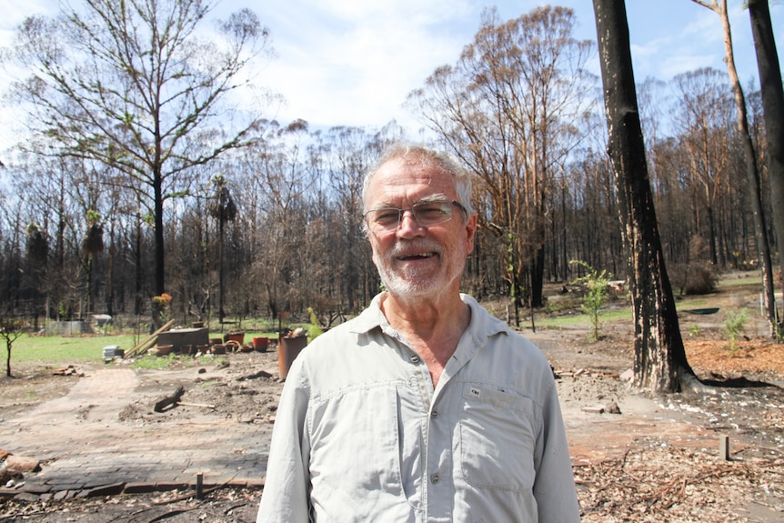 A man, Keiron Tapsell, stands on burnt barren ground.