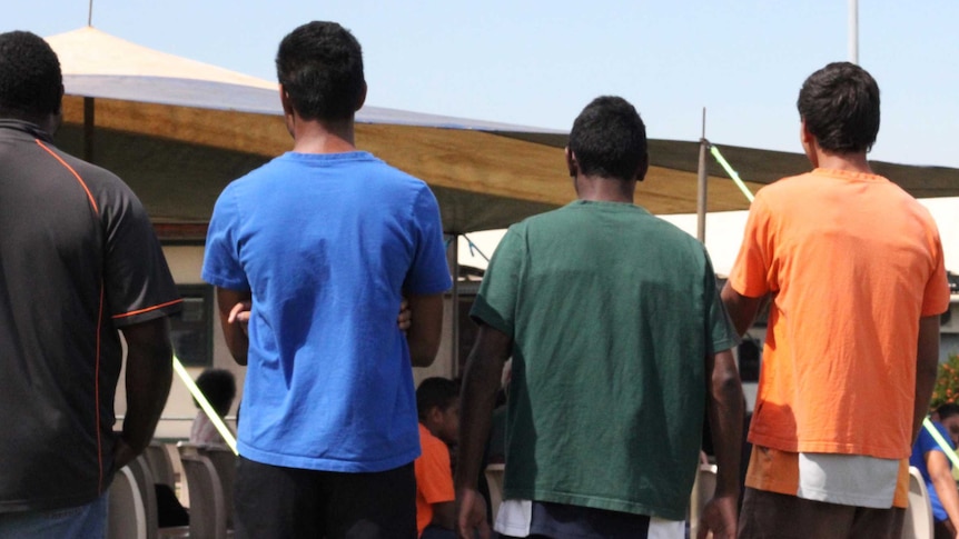 A group of young men with their backs to the camera.