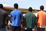 A group of young men with their backs to the camera.