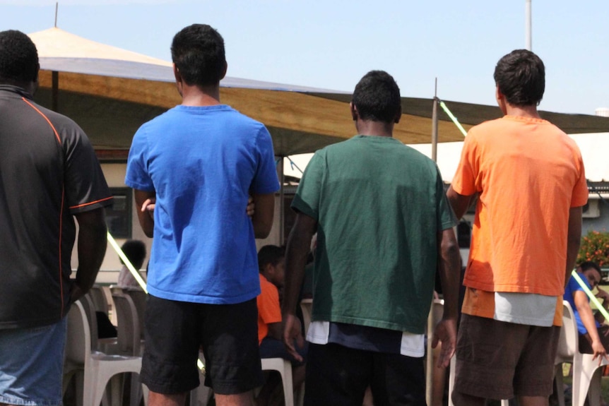 A group of young men with their backs to the camera.