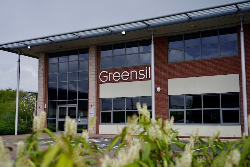 Edificio de oficinas de aspecto general con un cartel con el nombre Greensel.