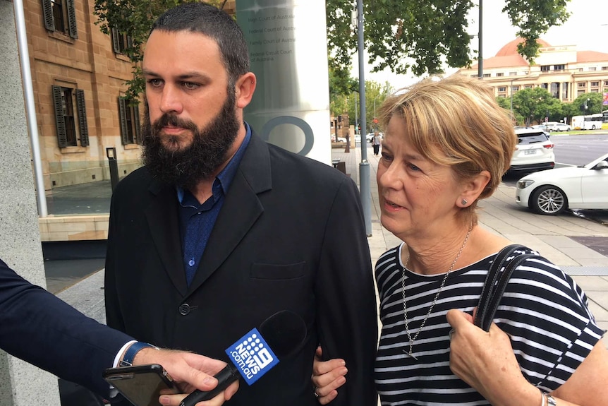 A man and a woman stand outside court