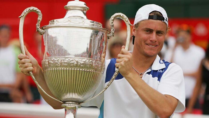 Australia's Lleyton Hewitt holds trophy after beating James Blake in 2006 Queen's Club final.
