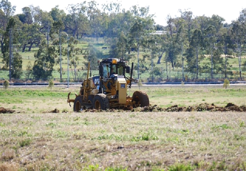 A tractor ploughs an open field