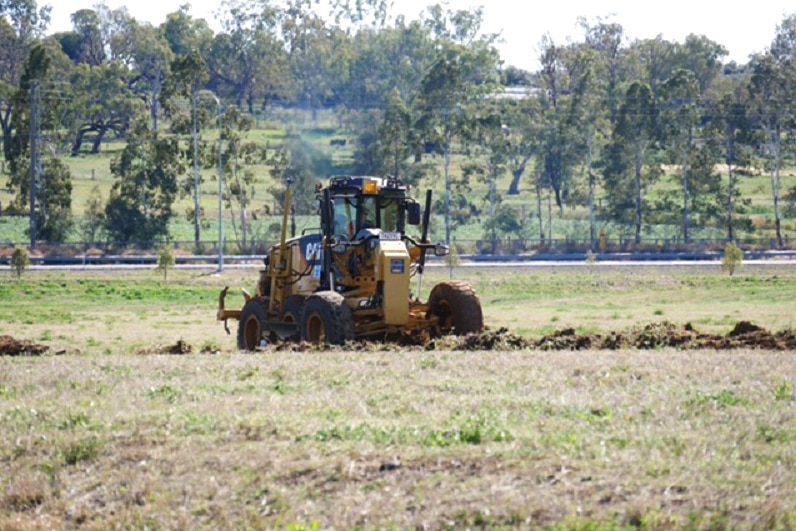 A tractor ploughs an open field