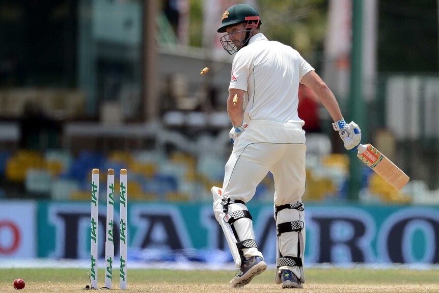 Australia's Shaun Marsh looks back towards his broken wicket after his dismissal by Sri Lanka's Suranga Lakmal