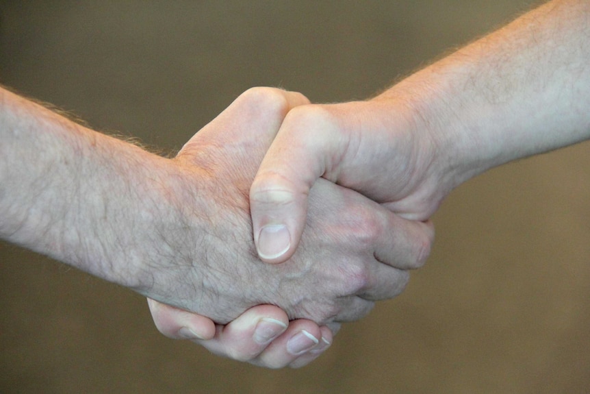 Two men shake hands