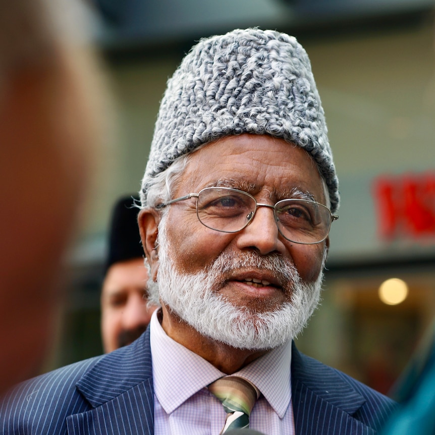 A man with a hat speaking to press