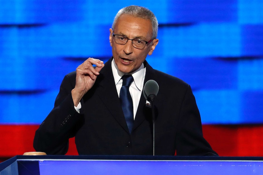 John Podesta makes a pinching motion with his hand as he speaks at the Democratic National Convention.