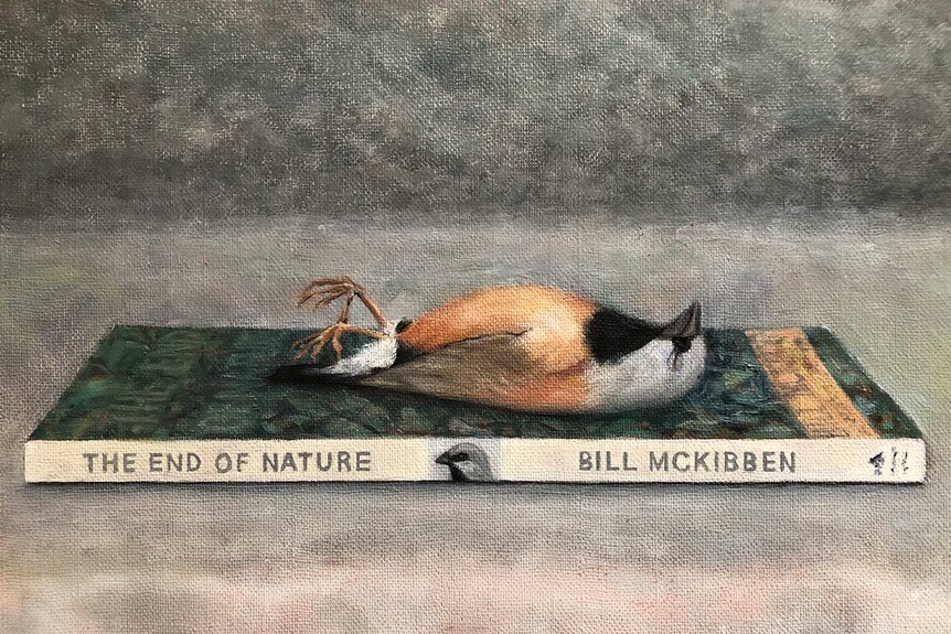 A painting of a dead black-throated finch lying on a book titled 'The End of Nature'.