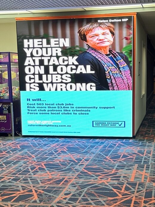 A large screen in a club reading 'Helen your attack on local clubs is wrong'