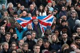 A crowd of people attend a vigil in Trafalgar Square for the London Attacks, a man in the centre holds a Union Jack flag.