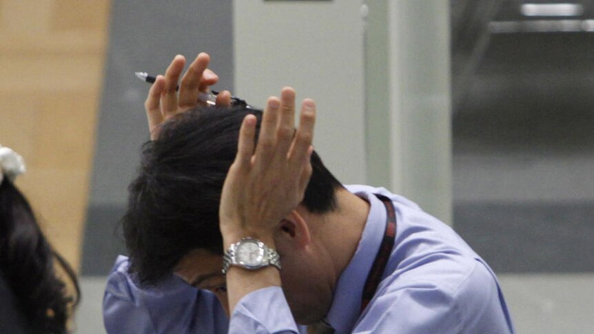 Japanese worker looks frustrated at the TSE