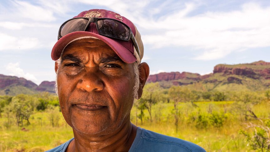 Local tour operator Ted Hall, stands in open bushland in Mandangala, Western Australia.