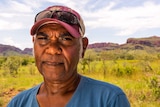 Local tour operator Ted Hall, stands in open bushland in Mandangala, Western Australia.