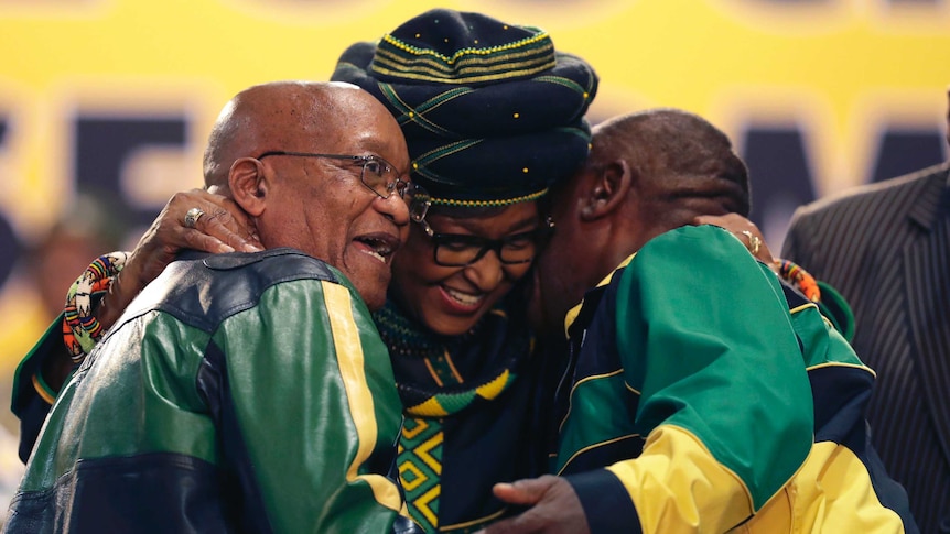 Winnie Madikizela-Mandela, centre, hugs front runner and Deputy President, Cyril Ramaphosa, right, and President Jacob Zuma