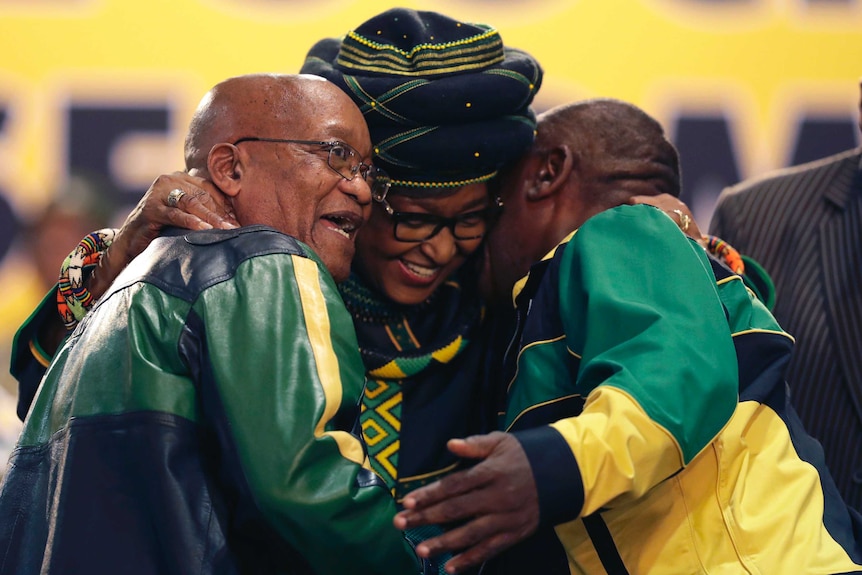 Winnie Madikizela-Mandela, centre, hugs front runner and Deputy President, Cyril Ramaphosa, right, and President Jacob Zuma