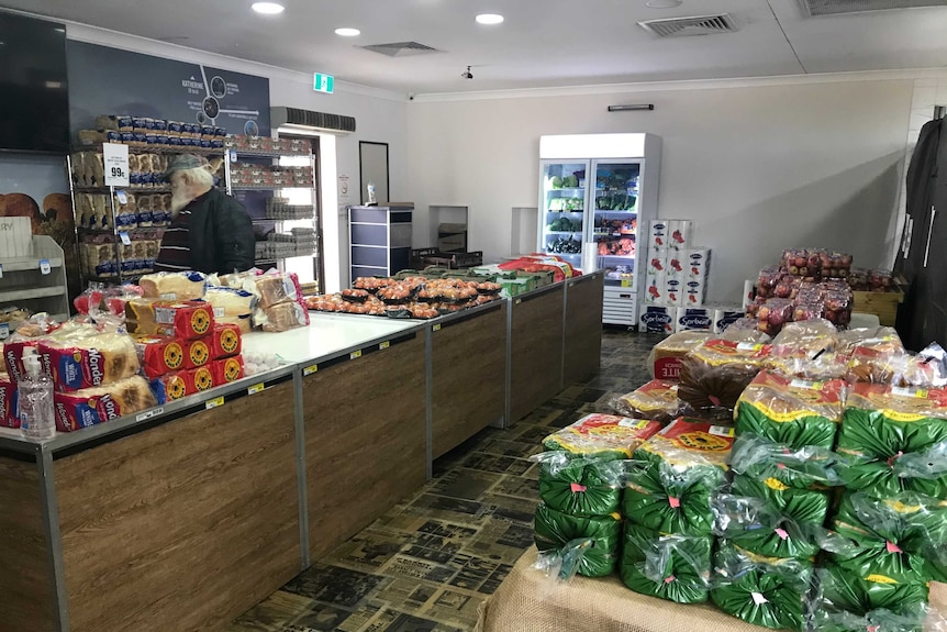 The interior of a service station with a table laden with groceries set up in the middle.