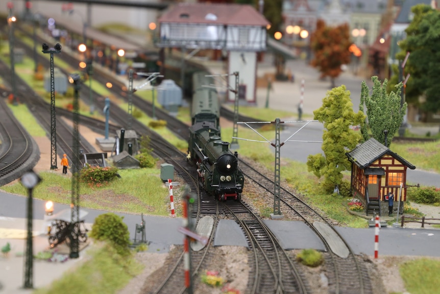 Model train on the tracks surrounded my miniature buildings 