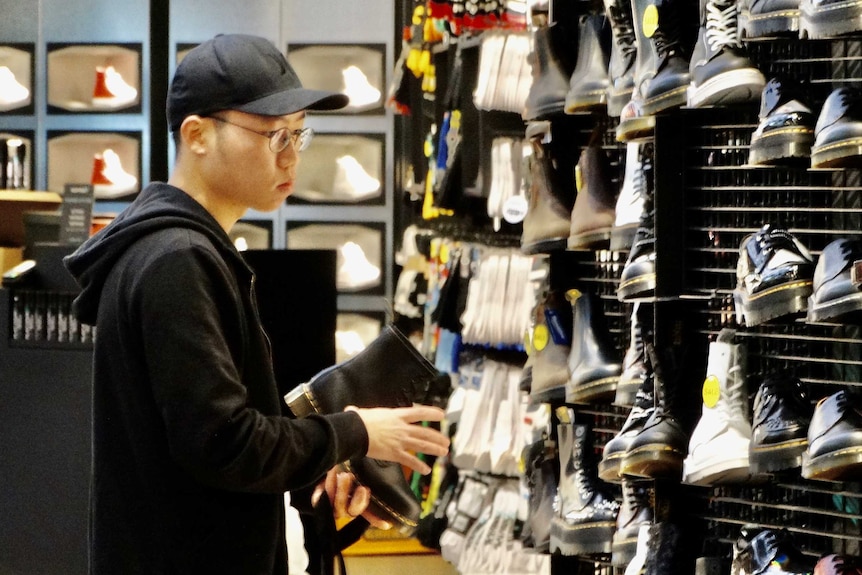 A man looks at runners in a shop in a Melbourne shopping centre