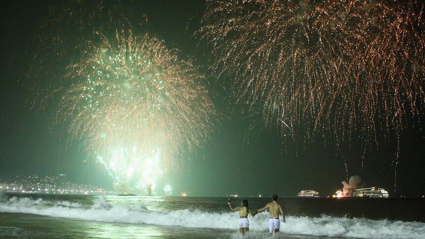 People watch fireworks along Copacabana Beach in Rio de Janeiro.