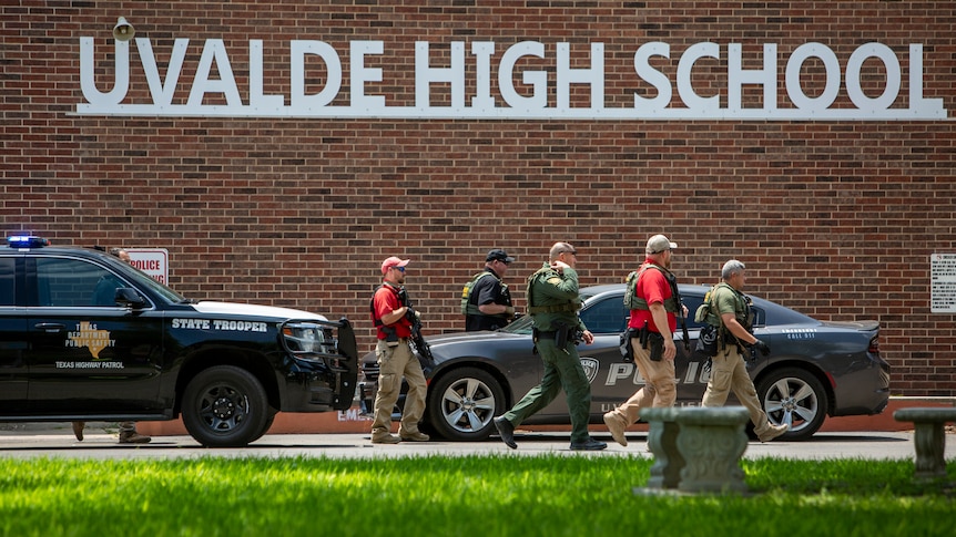 Police walk outside the school