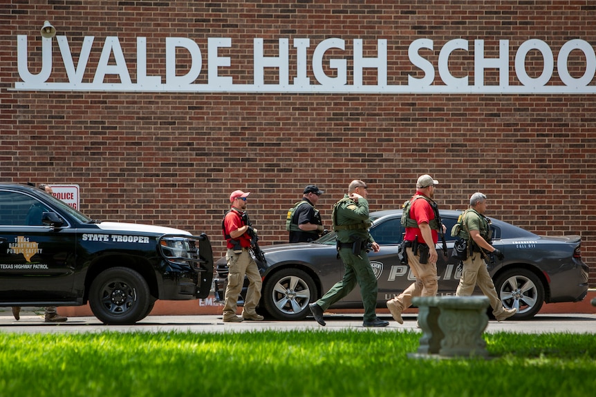 Police walk outside the school