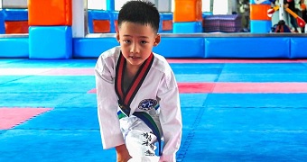 Bobby doing a split in a gym.