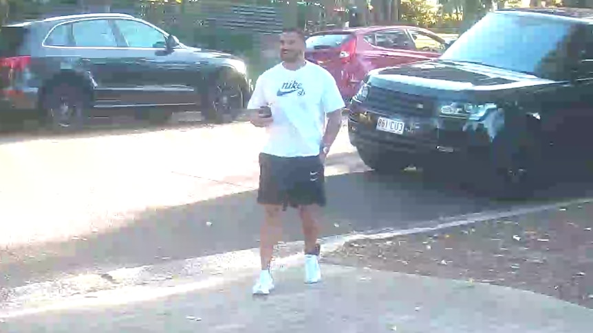 a man outside standing next to a car