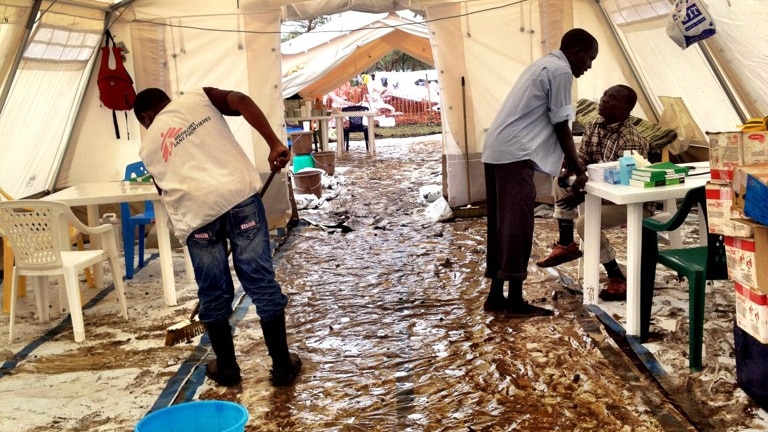 MSF workers clean up the clinic in Jamam after a night of rain.