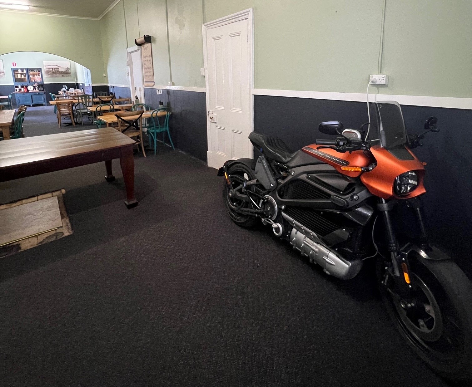Ed's orange and black electric Harley Davidson is plugged in as he sits in the dining room at the Spalding Hotel. 