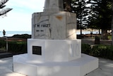 The base of a war memorial has the word no painted on it