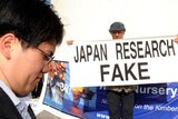 A member of the Japanese delegation walks past anti-whaling protestors