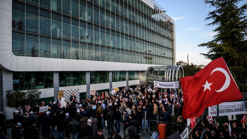 People demonstrate outside the headquarters of the Zaman newspaper