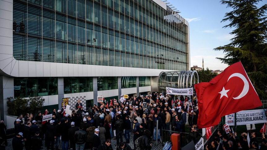 People demonstrate outside the headquarters of the Zaman newspaper