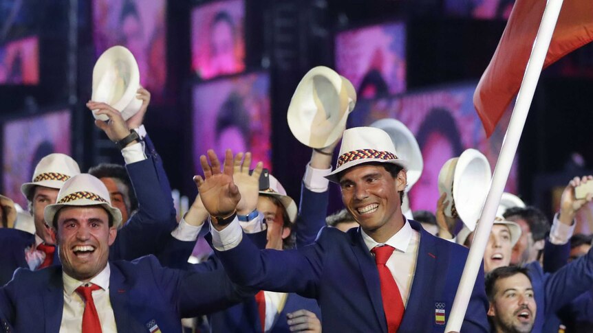 Rafael Nadal carries the flag of Spain