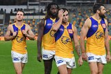 A number of Eagles players look dejected as they walk off the field after losing to Brisbane.